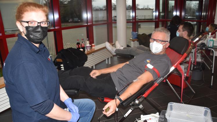 Schwester Nancy vom Blutspendedienst des Deutschen Roten Kreuzes zapft bei Hallenwart Peter Prochnow Blut ab. Er gehört zu den regelmäßigen Spendern.