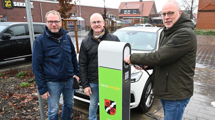 Auf dem Parkplatz an der Kirche in Eggermühlen gibt es eine Ladesäule für E-Fahrzeuge. Frank Stalfort, Thomas Jablonsky und Bürgermeister Markus Frerker nahmen sie in Betrieb.