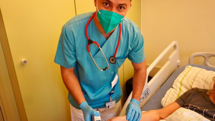  Kolumbianischer Krankenpfleger misst Puls, Temperatur und Blutdruck bei einer Patientin im Klinikum Osnabrück                          