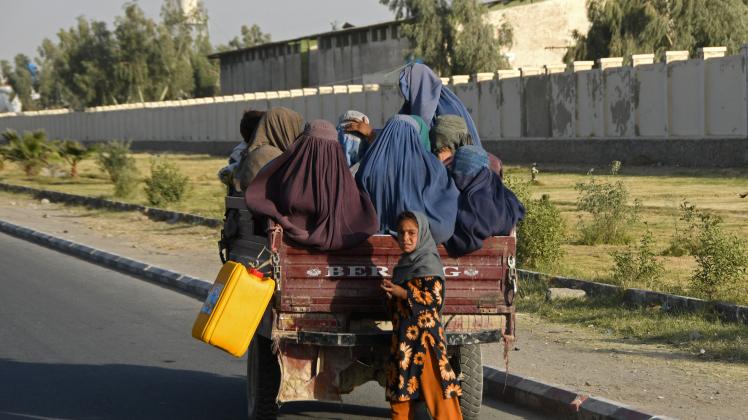 NAVEED TANVEER TOPSHOT - Afghan burqa-clad women travel in a vehicle along the road in Kandahar on December 25, 2022. (Photo by Naveed Tanveer / AFP)