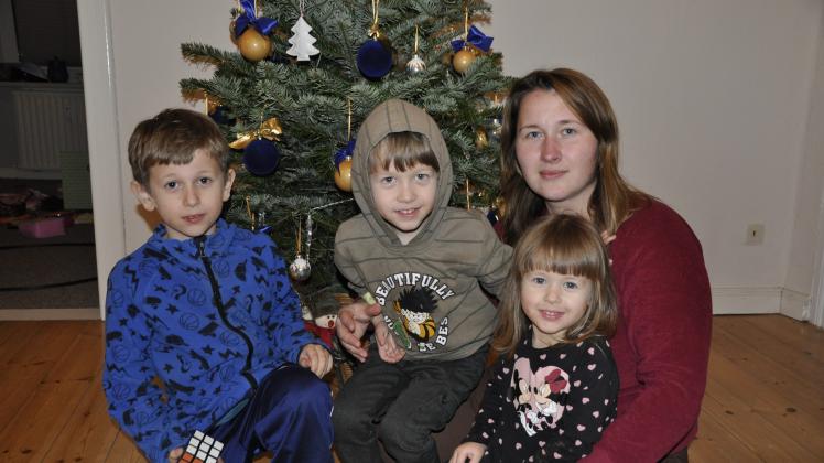 Marina Balagurchyk mit ihren Kindern Andrii, Artjom und Warwara (v.l.n.r.) vor dem Weihnachtsbaum.