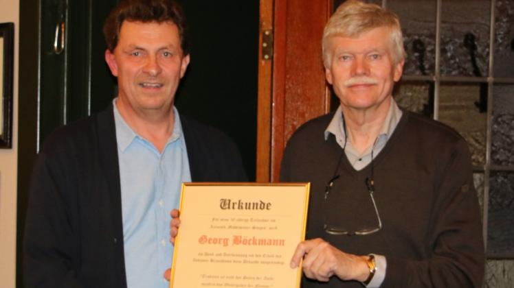 Für seine 50-jährige Teilnahme am Lienesch-Middewintersingen erhielt  Georg Böckmann (rechts) vom Heimatverein eine Urkunde, die  von Thomas Oeverhaus überreicht wurde