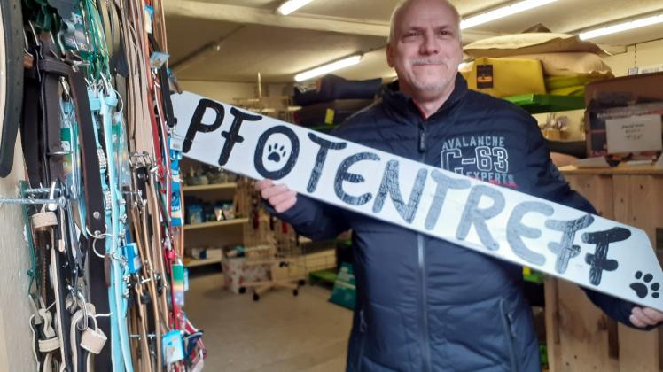 Tierfreund Andreas Czech hält stolz den von ihm erdachten Namen „Pfotentreff“ für den neuen Laden für Tierzubehör in den Händen