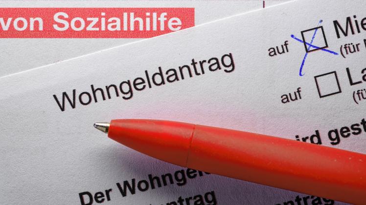 11.08.2022, Sachsen, Dresden: ILLUSTRATION - Ein Stift liegt auf einem Antrag von Sozialhilfe und einem Wohngeldantrag auf einem Tisch. (gestellte Szene) Foto: Robert Michael/dpa +++ dpa-Bildfunk +++