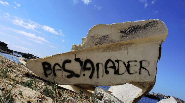 ZERBORSTENES FLÜCHTLINGSBOOT AM WILDEN STRAND VOM KÜSTENORT COLONIA DE SANT JORDI AUF MALLORCA ES S
