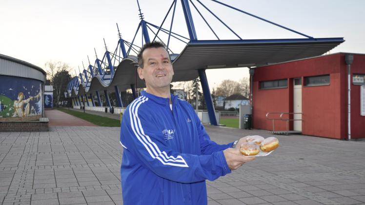 Gut gelaunt präsentiert Ralf Skopnik ein paar der vielen leckeren Pfannkuchen, die es im Ziel am Leichtathletikstadion für die Aktiven gab.
