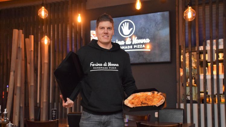 Gastronom Jochen Litkewitz zeigt den Prototyp eines Pizza-Mehrwegkartons, der für das Restaurant Farina di Nonna konzipiert wurde.