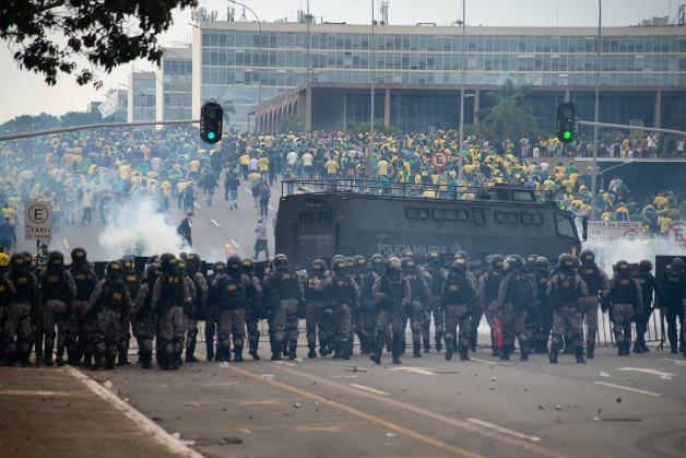 Die Anhänger des ehemaligen brasilianischen Präsidenten Bolsonaro (hinten) geraten in der Hauptstadt mit Polizisten aneinander.