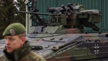 A German Bundeswehr soldier talks to media in front of an armoured "Marder" vehicle is pictured before the arrival of the German Defence Minister at a military base of an armored infantryman batallion in Marienberg, eastern Germany, on January 12, 2023. - Germany will supply Ukraine with about 40 Marder infantry fighting vehicles within weeks as part of a new phase of support coordinated with the US. (Photo by Odd ANDERSEN / AFP)