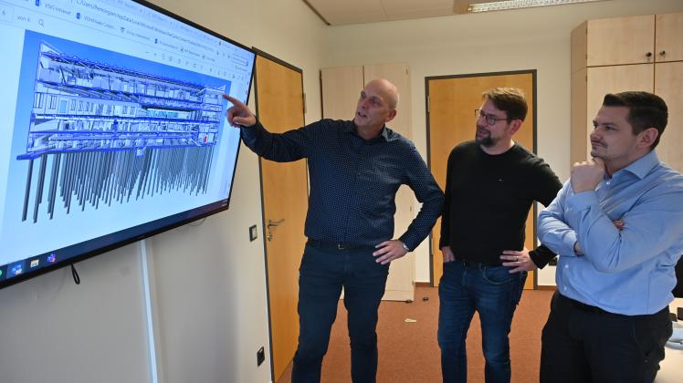 Standortleiter und Geschäftsführer Leif Henningsen (v.l.) erklärt seinen Kollegen Tilo Bormann und Christian Damean den Planungsstans der neuen Chipfabrik in Itzehoe.