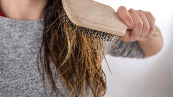 Eine Frau kämmt sich ihre langen und feuchten Haare