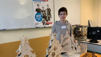 Der Siebtklässler Xandro Stiller zeigte den Weihnachtsschmuck, den die Mitglieder der Schülerfirma HolzaufHolz angefertigt haben. 