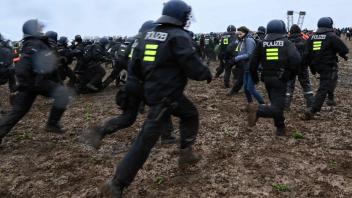 Police clashes with protesters during a large-scale protest to stop the demolition of the village Luetzerath to make way for an open-air coal mine extension on January 14, 2023. - In an operation launched earlier this week, hundreds of police have been working to remove activists, who have already occupied the hamlet of Luetzerath in western Germany. (Photo by INA FASSBENDER / AFP)