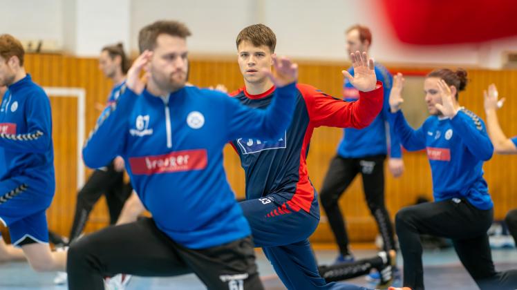 Ein Flensburger zwischen blauen „Teamkollegen“: Aaron Mensing bei der gemeinsamen Erwärmung mit den Spielern von Sönderjysk Elitesport.