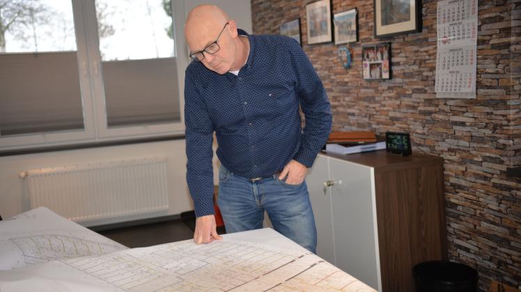 Thomas Hoffrogge betrachtet den Plan des Bauvorhabens „Weiße Dame“ in Gronau.