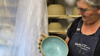 Maria Ziaja räumt gebrannte Keramik aus dem Ofen.