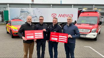 Eingerahmt von Einsatzfahrzeugen und Mewa-Sattelzug freuen sich Detlef Glimm, Christian Mundhenk, Lars Heuer und Jörg Naegeli (v.l.) über Spenden für die Feuerwehren in Boizenburg und Lauenburg.