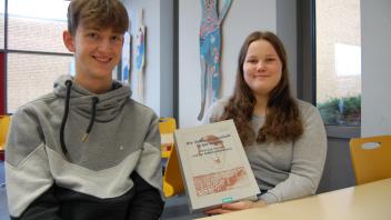 Melf Deusen und Emmily Kohlmüller mit dem neuen Buch für die Schulbibliothek.