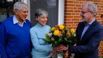 Propst Jürgen Jessen-Thiesen (rechts) überreicht den beiden Kirchen-SpendernAstrid und Goolam Kalla einen Blumenstrauß. 