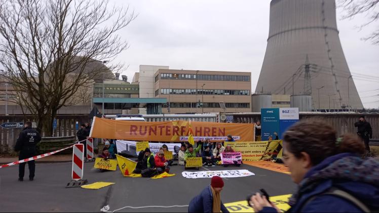 Etwa 30 Aktivisten der Initiative „Runterfahren“ haben sich vor dem Hauptzufahrtstor des Atomkraftwerks in Lingen niedergelassen.