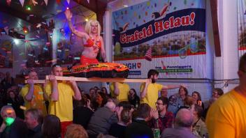 Der Einmarsch der Männertanzgruppe bei der Gala der Grafelder Karnevalisten - im Gummiboot „Pamela Anderson“, getragen von den Rettungsschwimmern von Malibu, gemimt von kantigen Grafeldern.