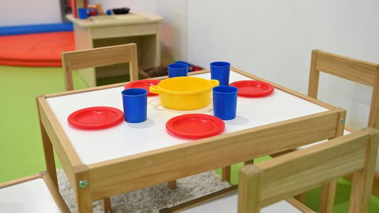 leerer Kindertisch und Kinderstuehle mit Essgeschirr und Becher in der Sprach-Kita ãKinderkrippe NeuhausenÒ in Muenchen 