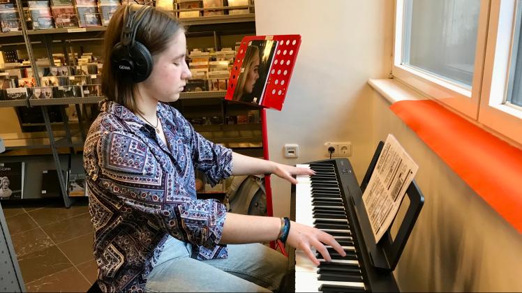 eine junge Frau an einem E-Piano