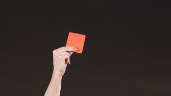 Young soccer referee holding up red card during sunset PUBLICATIONxINxGERxSUIxAUTxONLY Copyright Ad