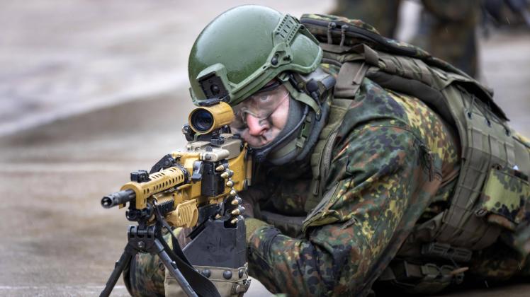 Ein Soldat mit Maschinengewehr MG5 zielt bei einer Präsentation am 12.01.2023 in der Erzgebirgskaserne in Marienberg. Da