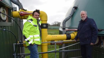 Bürgermeister Jens-Peter Frank (r.) informiert sich bei Geschäftsführer Jan Joost über die Einzelheiten der Firma Dujos, die in Holtsee ein Nahwärmenetz aufbauen möchte. Sie stehen vor einem Verbindungsrohr zwischen zwei Fermentern, wo die organische Substanz abgebaut und das Biogas gebildet wird.