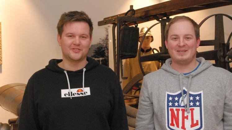Felix Bugdol (l) und  Pascal Kirk vor historischem Löschzug in der neuen Hasberger Feuerwehrwache 
