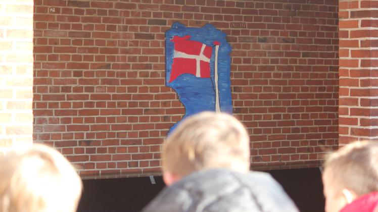 Schüler der dänischen Schule Niebüll sitzen am 8. Februar 2023 auf einer Bank im Pausenhof der Schule.