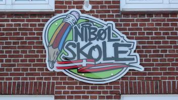 Schild an der Fassade der dänischen Schule in Niebüll.