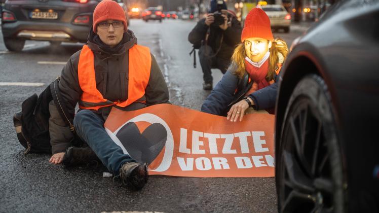 Blockade der Letzten Generation in München Aktivist*innen sitzen vor Autos auf der Straße. Aktivist*innen der Letzten G