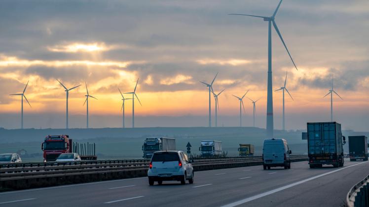 Autobahn A44, bei Jüchen, durchquert das Braunkohle Tagebaugebiet Garzweiler, Windpark entlang der Autobahn, Sonnenaufga