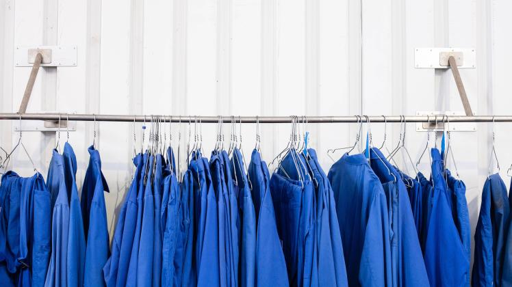 Blaue Arbeitskleidung, Blaumänner hängen auf einem Bügel an einer Stange Düsseldorf Nordrhein-Westfalen Deutschland *** 