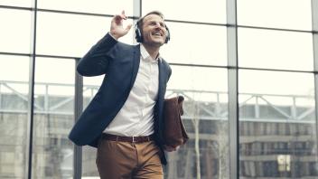 Happy businessman listening to music with headphones model released Symbolfoto property released PUB