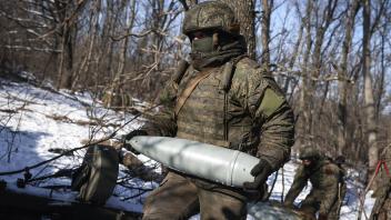 RUSSIA - FEBRUARY 8, 2023: A crewman carries a shell for a D-20 towed gun-howitzer of Russia’s Central Military District