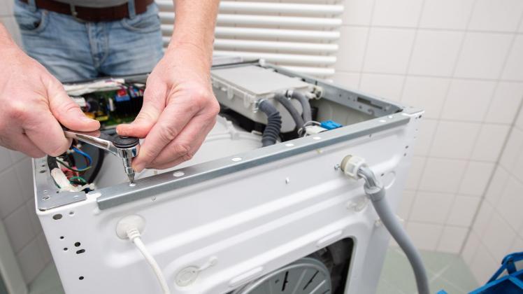 Ein Handwerker repariert eine Waschmaschine