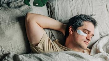 Man with under eye patches sleeping in bedroom model released, Symbolfoto, VSNF00372