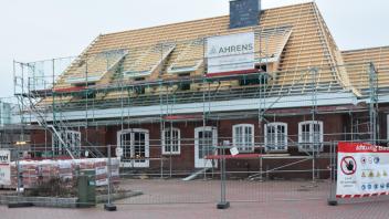 Die Sanierungsarbeiten sind noch längst nicht abgeschlossen, der Dachstuhl aber steht schon mal: Flammen haben das historische Bahnhofsgebäude in Ganderkesee 2020 schwer beschädigt.