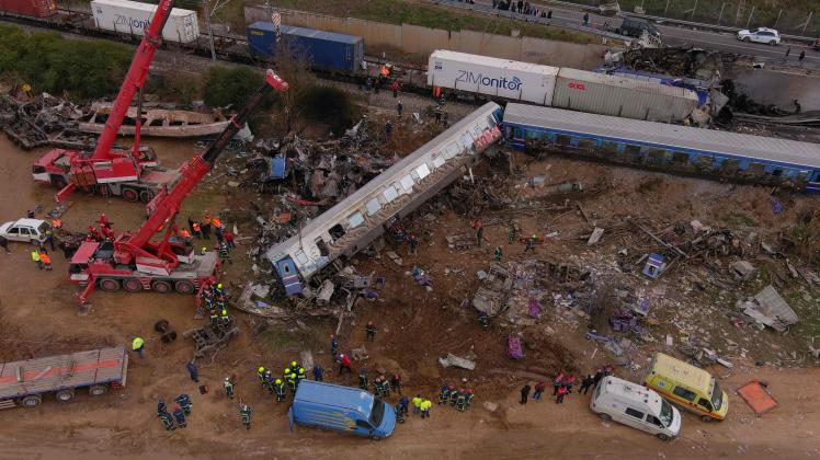 This aerial drone photograph taken on March 1, 2023, shows emergency crews examining the wreckage after a train accident in the Tempi Valley near Larissa, Greece. - At least 32 people were killed and another 85 injured after a collision between two trains caused a derailment near the Greek city of Larissa late at night on February 28, 2023, authorities said. A fire services spokesman confirmed that three carriages skipped the tracks just before midnight after the trains -- one for freight and the other carrying 350 passengers –- collided about halfway along the route between Athens and Thessaloniki. (Photo by STRINGER / AFP)