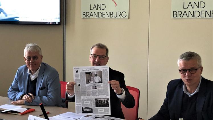 Wirtschaftsstaatssekretär Hendrik Fischer präsentiert die alte Ausgabe des Tagesspiegels.