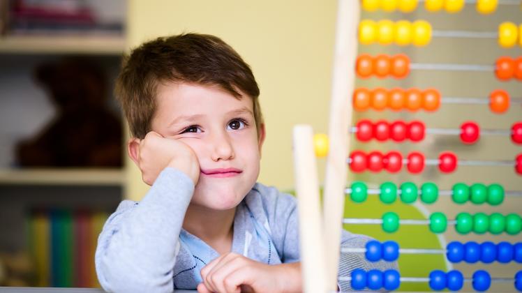 RECORD DATE NOT STATED A Caucasian toddler boy feeling bored and tired while playing with abacus at kindergarten *** ein
