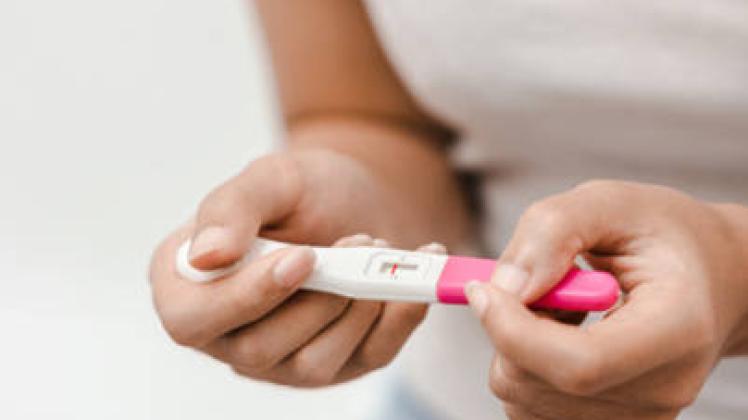 February 9, 2023: Unhappy young asian woman holding pregnancy test showing a negative result in her bathroom, wellness a