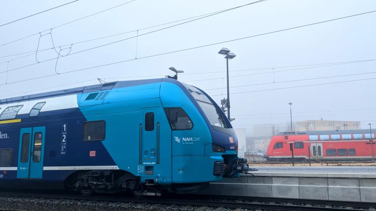 Ein neuer Kiss-Zug der Deutschen Bahn im Bahnhof Bad Oldesloe. Im Hintergrund einer der alten roten Doppelstockwagen.