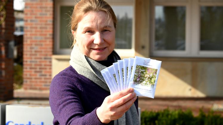 Das Foto zeigt Kirsten Flathmann-Matz, Fachdienstleiterin Natur und Klimaschutz, mit einer Auswahl an Blumenwiesenmischungen.