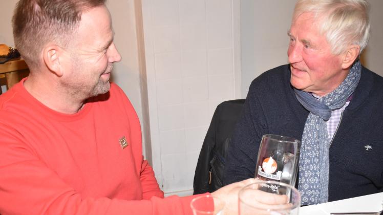 Der Kniesenack-Verein sammelt alles, was mit dem Kniesenack-Bier zusammenhängt. Auf diesem Glaskrug, ist ein roter Kniesenack-Zwerg auf schwarzem Grund zu sehen. Alexander Wulf (l.) fand ihn über Facebook. Auf dem Krug ist der Name G. Sagemüller zu lesen und darunter Teschners Hotel, Güstrow,. Georg Sagemüller (r.) vermutet, dass dieses Original-Glas aus den 1920/30er-Jahren stammt. Auch meint er, dass der rote Kniesenack-Zwerg wohl der ursprüngliche Zwerg für das Logo des Biers war. Eine genaue Jahreszahl, wann das rote und das grüne Logo entstanden, ist nicht bekannt.