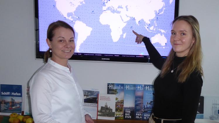 Auf einem Bildschirm sind die aktuellen Positionen der Schiffe der Rostocker Reederei F. Laeisz zu sehen. Davor die Rostockerin Anna Halirsch (r.) und Sovanny Trott, Managerin Human Resources der Reederei. 