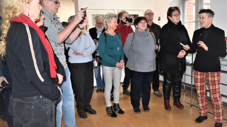 Fotografin Anne Jüngling (r.) erklärt den Besuchern der Vernissage, warum sie die symbolische Blume als Gegenstand ihrer Arbeiten ausgewählt hat.